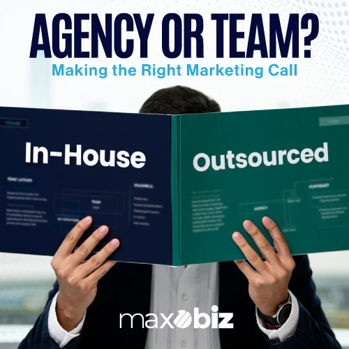 Person holding a booklet comparing in-house and outsourced marketing with headline ‘Agency or Team? Making the Right Marketing Call’ by Maxobiz