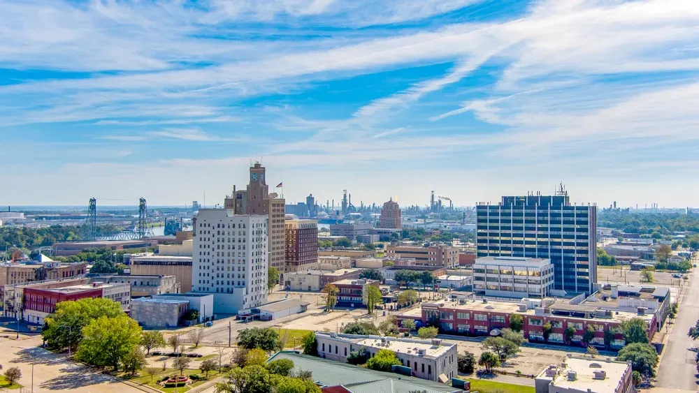 Aerial view of downtown Beaumont, Texas, featuring historic and modern buildings under a bright blue sky