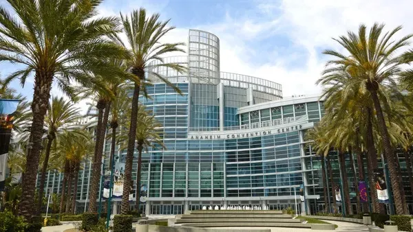Anaheim Convention Center surrounded by palm trees under a clear sky in Anaheim, California.