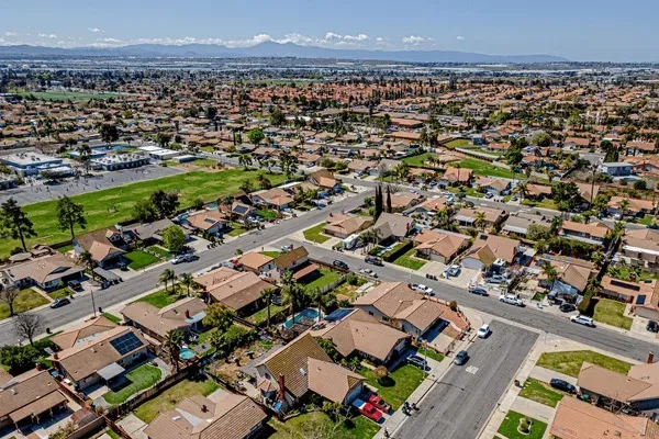 Aerial view of residential neighborhoods in Moreno Valley, CA with rows of houses, streets, and open green spaces