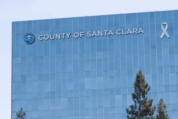 County of Santa Clara government building with glass windows and white ribbon symbol on the facade