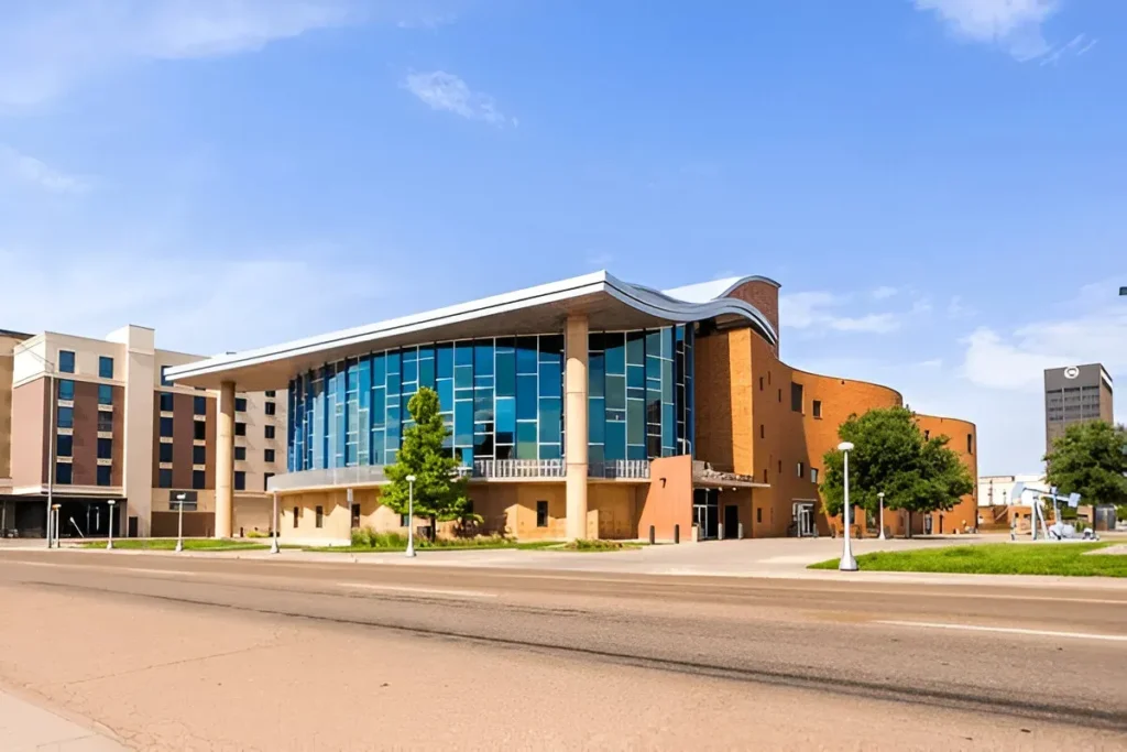 Modern architectural building in downtown Amarillo, Texas, with glass façade and surrounding urban landscape on a sunny day