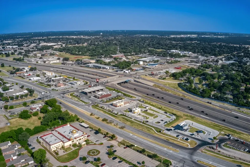 Aerial view of Euless, Texas showcasing highways, local businesses, and green residential areas under a clear blue sky – ideal for digital marketing presence.