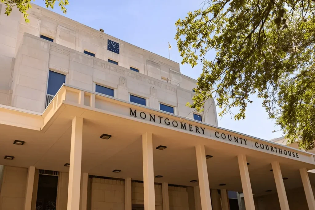 Montgomery County Courthouse building in Conroe, Texas, showcasing historic architecture with large columns under a clear blue sky.